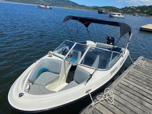 a white boat parked at a dock on the water at Knysna Retreat - Knysna River Club in Knysna