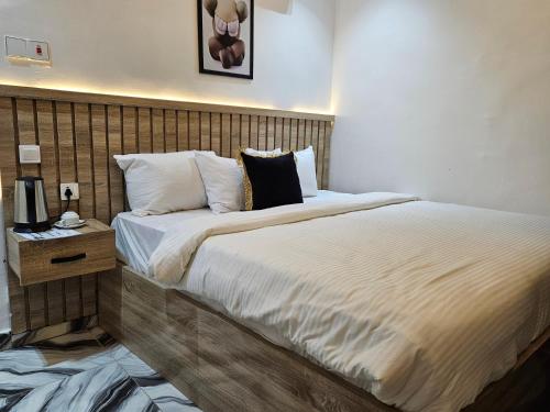 a hotel room with two beds and a night stand at SBP Hotel in Benin City