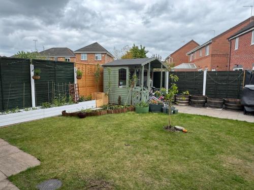 a garden with a green shed in a backyard at Newly built studio apartment in Manchester
