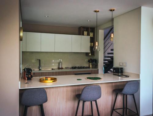 une cuisine avec deux tabourets de bar et un comptoir dans l'établissement Maison Eden, à Armenia