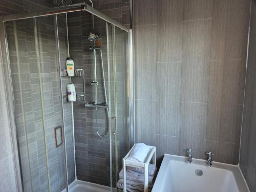 a bathroom with a shower and a tub and a sink at private room with shared bathroom 20 minutes walk to Durham centre in Gilesgate