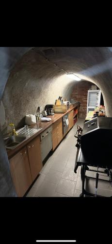 a kitchen with a sink and a stove in a tunnel at Vinný sklípek s ubytováním in Bořetice