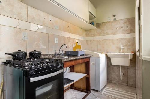 eine Küche mit Herd und Spüle in der Unterkunft Apartamento Grande e Climatizado em Florianópolis in Florianópolis