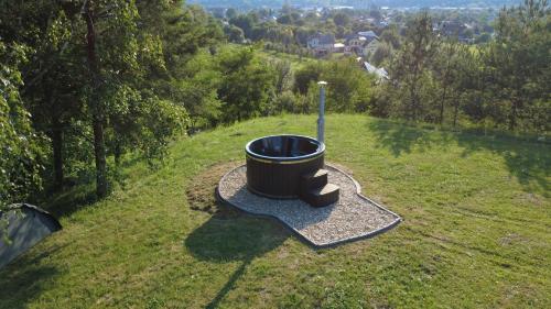 a barrel sitting in the middle of a grass field at Casa Tirol Campulung in Câmpulung