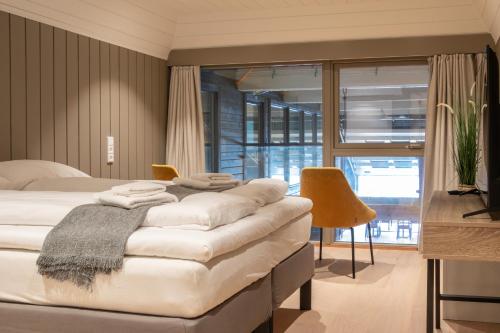 a bedroom with a bed and a table and chairs at Villa Oleanna in Lysekloster