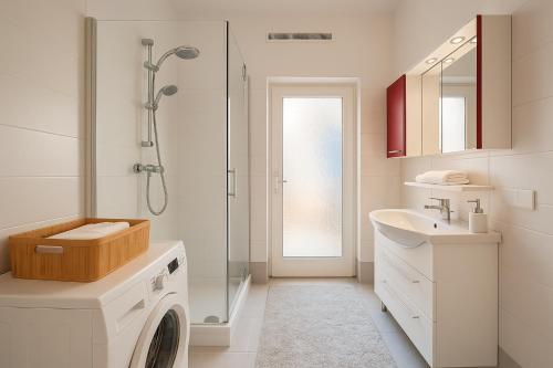 a bathroom with a washing machine and a sink at Salzburg Topside Apartments in Salzburg