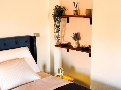 a bedroom with a bed and two shelves on the wall at Suite del Castello in Massino Visconti
