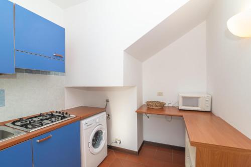 a kitchen with a washing machine and a microwave at Villa Selena in Cuile Pazzoni