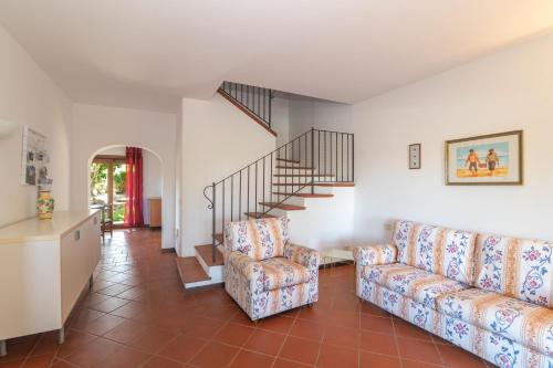 a living room with two couches and a staircase at Villa Selena in Cuile Pazzoni