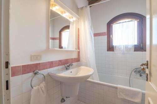 a white bathroom with a sink and a mirror at Villa Selena in Cuile Pazzoni