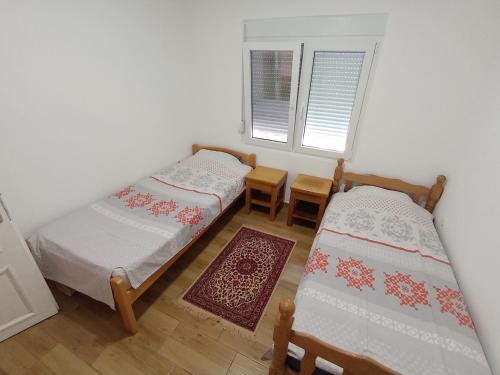 a room with two beds and a table and chairs at Smeštaj Golubica in Soko Banja