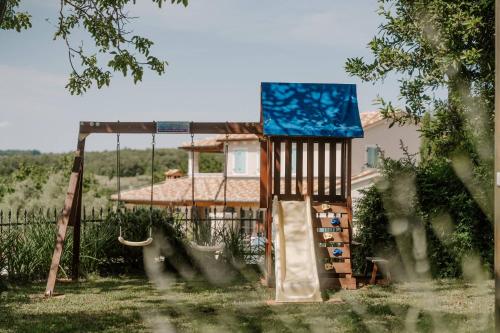 a playground with a slide in front of a house at Villa Lilly in Višnjan
