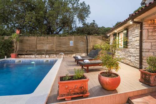 a backyard with a swimming pool and a wooden deck at Villa Lilly in Višnjan