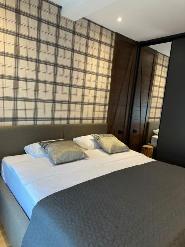a large bed with two pillows on top of it at MODERN MOUNTAIN II in Kolašin