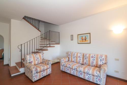 a living room with two chairs and a staircase at Villa Selena in Cuile Pazzoni