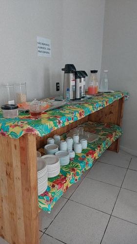 a counter with plates and bowls on a table at Pousada Bomfim in Maceió