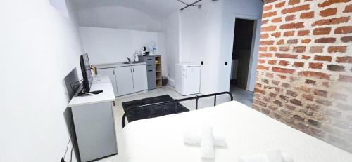 una stanza bianca con una cucina e un muro di mattoni di Wagner's refuge 4 a Riga