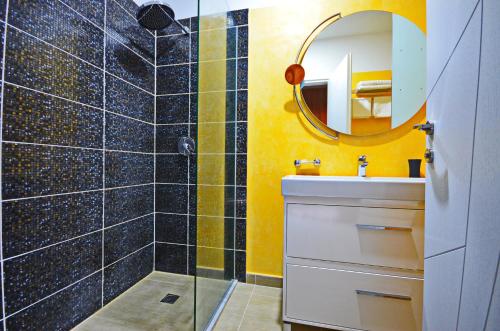 a bathroom with a shower and a sink and a mirror at PALMA city HOTEL in Sarandë