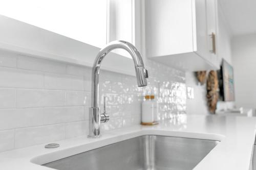 a kitchen sink with a faucet on top of it at The Hangout House Relaxed 4BR Luxury, 3 King Suites, Walk to Beach, Pet Friendly in Gulf Shores