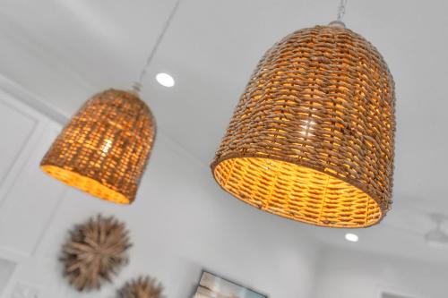 two wicker lights hanging from a wall at The Hangout House Relaxed 4BR Luxury, 3 King Suites, Walk to Beach, Pet Friendly in Gulf Shores