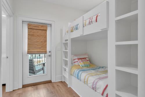 a childs room with white walls and a window at The Hangout House Relaxed 4BR Luxury, 3 King Suites, Walk to Beach, Pet Friendly in Gulf Shores