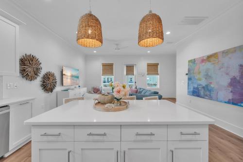 a kitchen with white cabinets and a living room at The Hangout House Relaxed 4BR Luxury, 3 King Suites, Walk to Beach, Pet Friendly in Gulf Shores