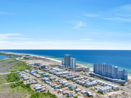 an aerial view of a beach with condos and the ocean at The Hangout House Relaxed 4BR Luxury, 3 King Suites, Walk to Beach, Pet Friendly in Gulf Shores