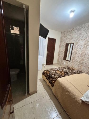 a bedroom with a bed and a bathroom at Suíte Aconchego 2 in Miguel Pereira
