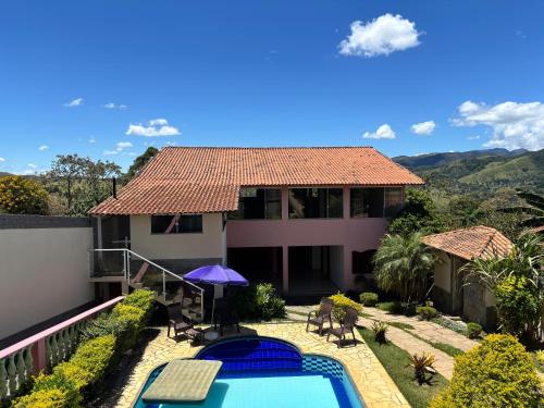 a villa with a swimming pool and a house at Suíte Aconchego 2 in Miguel Pereira