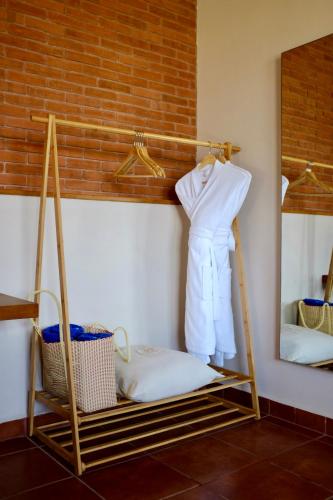 a room with a shelf with a white robe and a mirror at La Posada Hotel Boutique in Manzanillo