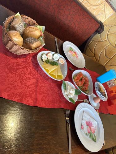 a table with a basket of bread and plates of food at Pizzeria & Pension ETNA in Waren