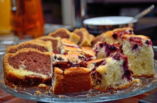a blueberry cake on a glass plate on a table at Penzion Na Vršku in Branná