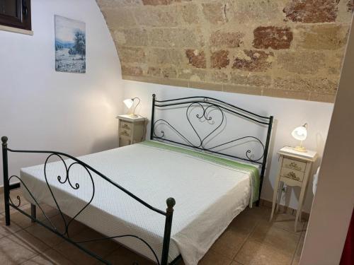 a bedroom with a black bed with two night stands at La payara di nonna nina in Tiggiano