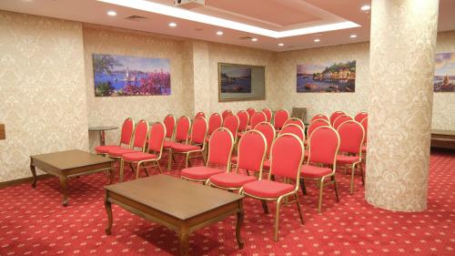 a room with red chairs and tables and paintings at İstanbul Trend Hotel Old City in Istanbul