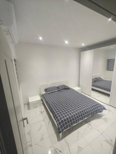 a white room with a bed and a mirror at Carina Mansion in Birżebbuġa