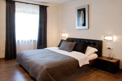 a bedroom with a large bed and a large window at Apartamenty Hotelu Pod Orłem in Toruń
