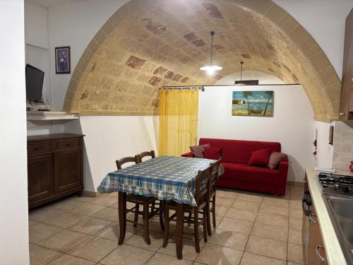 a living room with a table and a red couch at La payara di nonna nina in Tiggiano