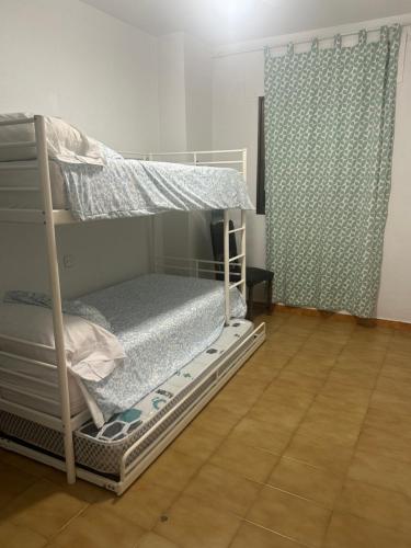 a bunk bed in a room with a curtain at Dúplex con vistas panorámicas in Calabardina