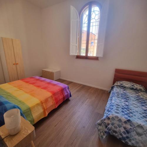 a room with two beds and a window at A due passi in Certaldo