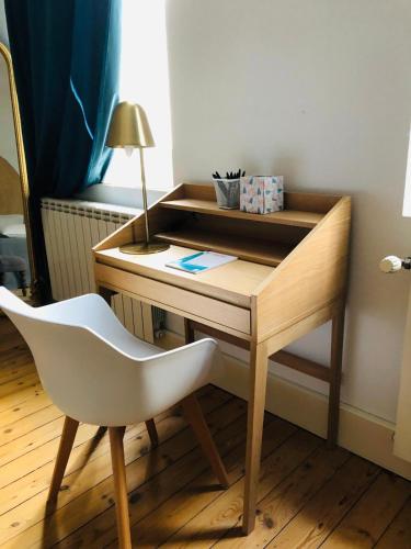 a desk with a white chair and a desk with a lamp at Casita El Lobo in Montech