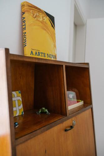 a book is sitting on top of a wooden cabinet at Good Old Days - Guesthouse in Caldas da Rainha