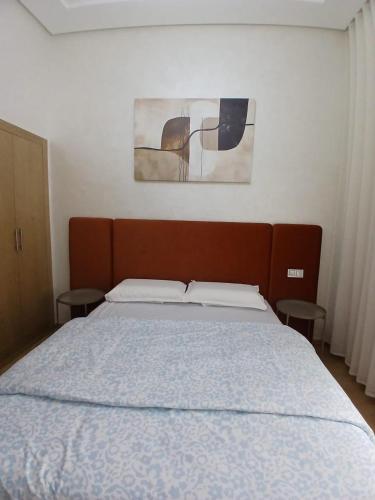a bedroom with a large bed with two tables at Studio Moderne avec Vue sur piscine et proche de la plage à Ocean Park Zenata Eco City in Aïn Harrouda