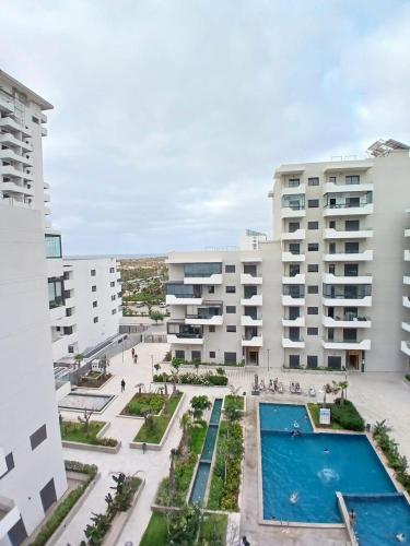 an apartment with a swimming pool and buildings at Studio Moderne avec Vue sur piscine et proche de la plage à Ocean Park Zenata Eco City in Aïn Harrouda