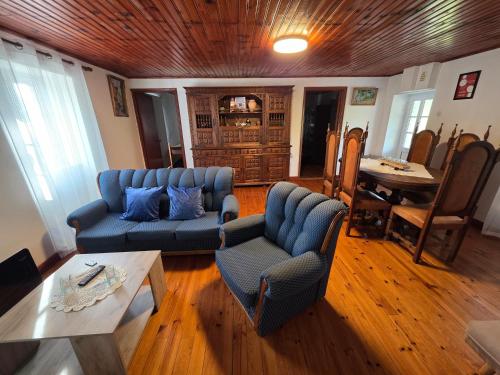 a living room with two blue couches and a table at Casa de Cabecinho- Albufeira do Azibo in Bragança