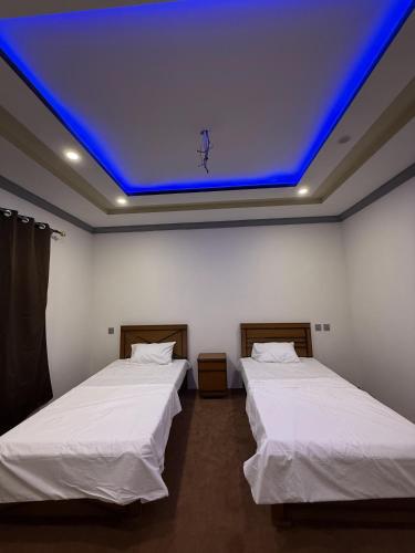 two beds in a room with a blue ceiling at Aba-SHAH GUEST HOUSE SKARDU in Skardu