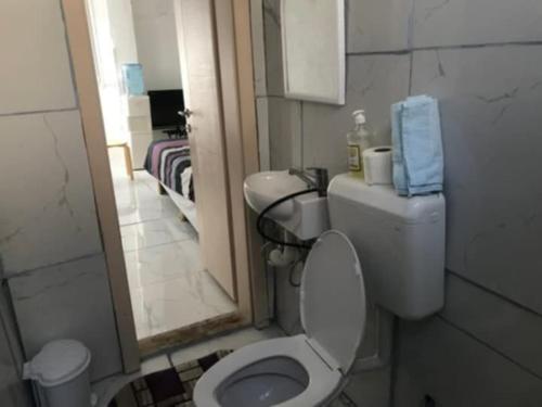 a bathroom with a white toilet and a mirror at Rooms Struga in Struga