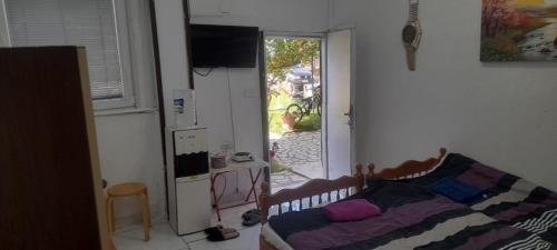 a bedroom with a bed and a refrigerator and a window at Rooms Struga in Struga