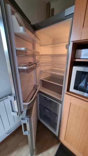 an empty refrigerator with its door open in a kitchen at Vressence in Vresse-sur-Semois