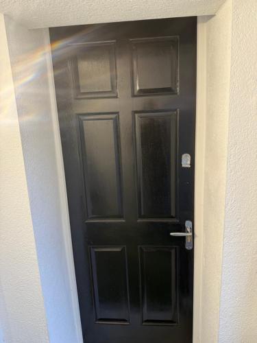 a black door in a hallway of a house at Large Studio Flat in heart of Camden market in London
