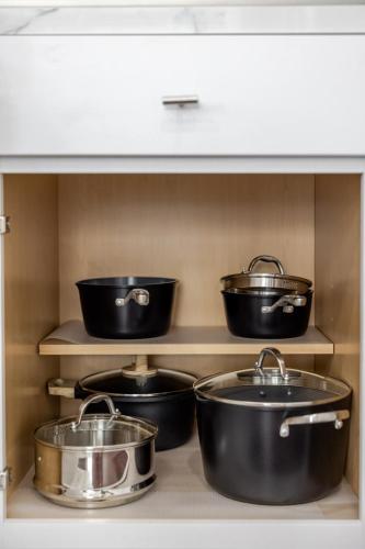 a shelf with four pots and pans in a kitchen at New Reno Retreat 72 Inch TV Office Patio Views in Reno